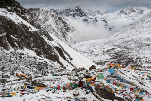 Drolma-La Pass and the snow covered mountain landscape at Mount Kailash with prayer flags; Burang County, Ngari Prefecture, Tibet Autonomous Region, Tibet photo