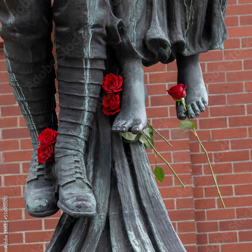 'Angel of Victory' bronze sculpture, a historic war memorial with fresh red roses placed on the feet of the sculpture; Vancouver, British Columbia, Canada