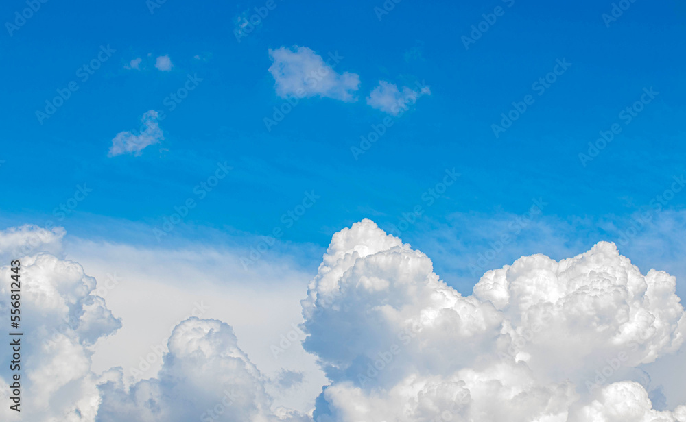 White cumulus clouds in the blue sky, illuminated by the bright spring sun.