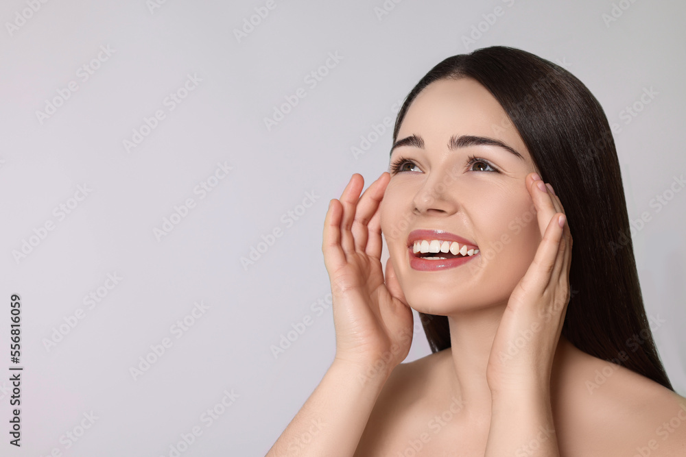 Portrait of attractive young woman on light grey background, space for text. Spa treatment Portrait of attractive young woman on light grey background, space for text. Spa treatment