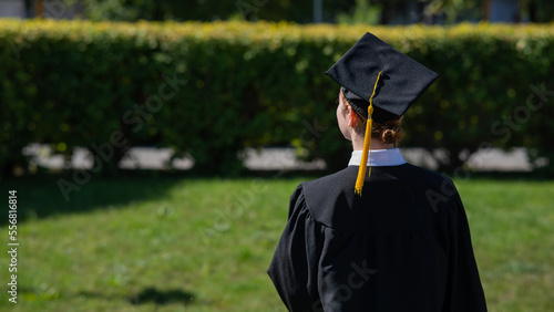 Foto A woman throws her graduation cap against the blue sky.