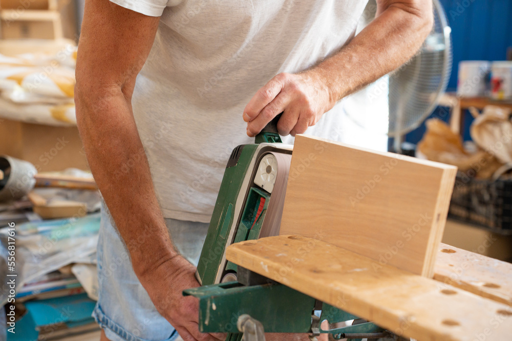 Unrecognizable carpenter working on wood craft at workspace producing wooden furniture with professional tools for crafting. High quality photo