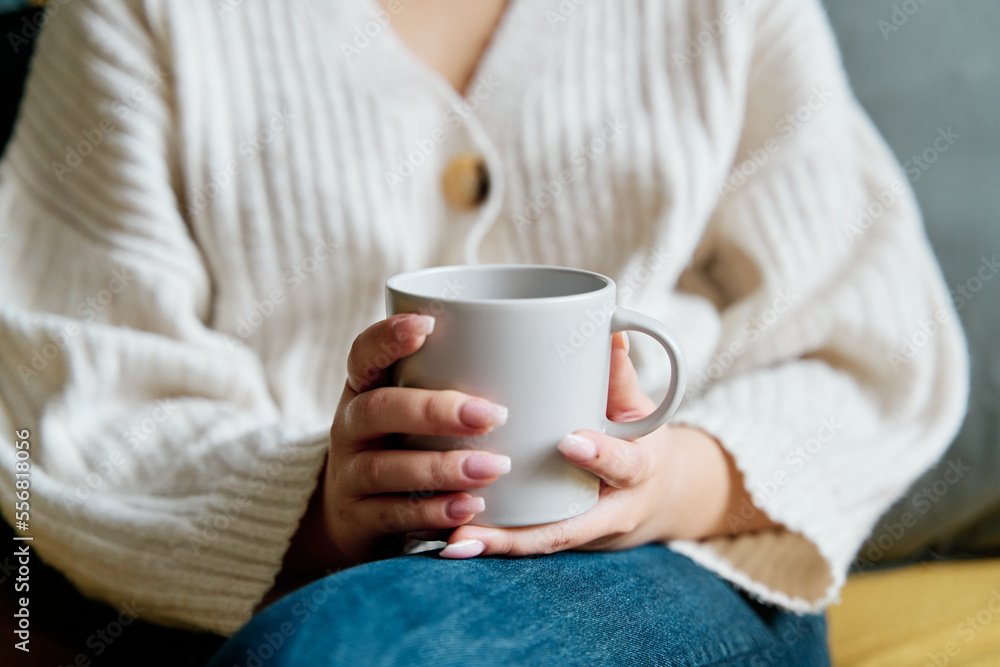 High angle of mug of hot beverage sitting on sofa and resting at home High angle of mug of hot beverage sitting on sofa and resting at home