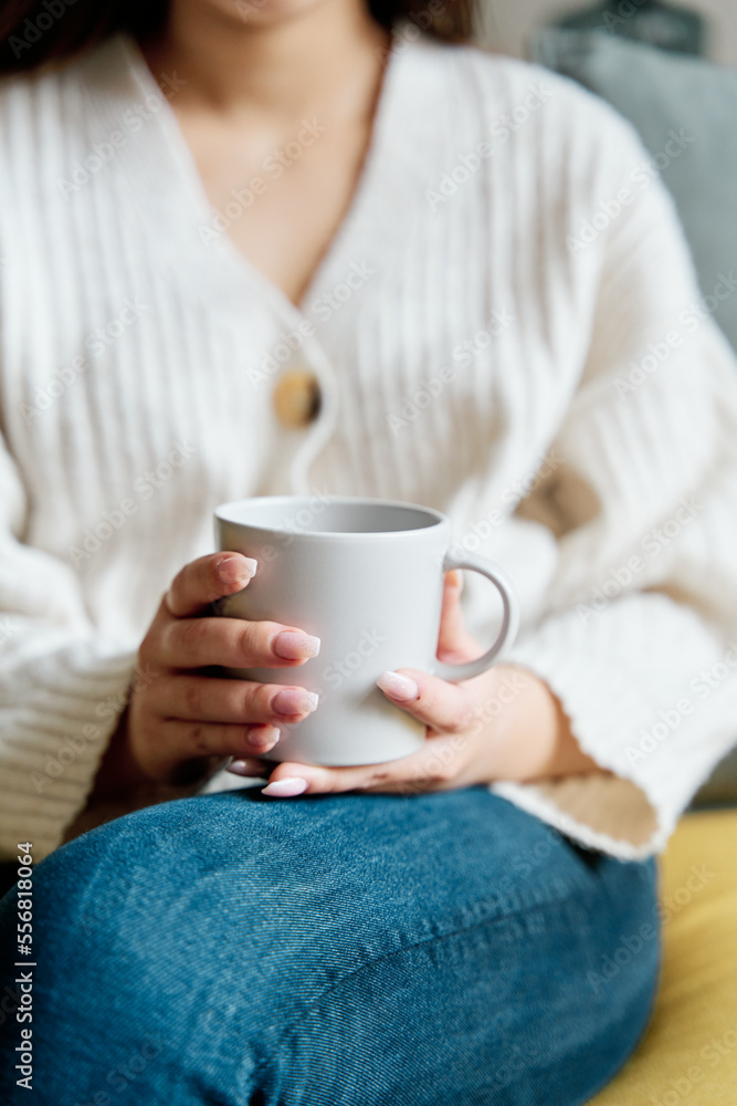 High angle of mug of hot beverage sitting on sofa and resting at home High angle of mug of hot beverage sitting on sofa and resting at home