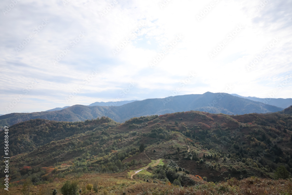 Picturesque view of green hills and mountains under cloudy sky Picturesque view of green hills and mountains under cloudy sky