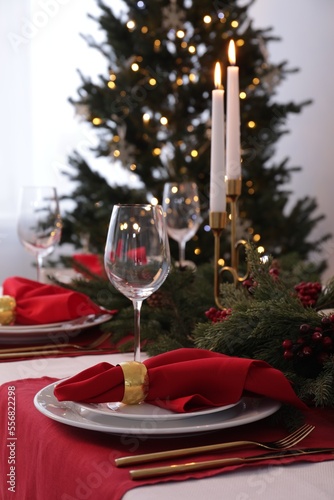 Beautiful place setting with Christmas decor on table indoors