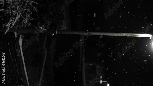 First Snowfall Overlay in United Kingdom Black Background. Falling Snowflakes in Light of Street Lamp at Night Road - Winter, Slowly falling snow effect. Weather Forecast, Anomaly, Emergency Concept photo