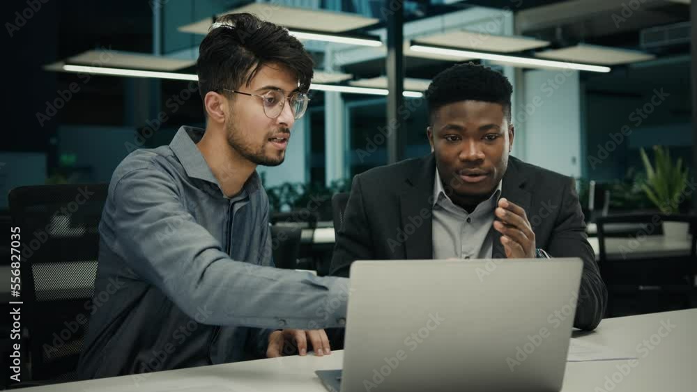 Businessman african man lawyer mentor help male indian client with computer work consult customer explain online business software services ethnic men colleagues look at laptop screen office meeting