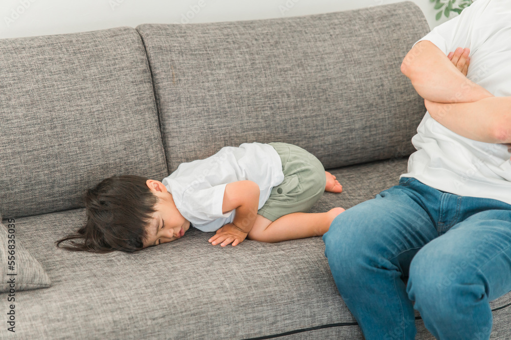 ソファで怒る父親とすねる子供(イヤイヤ期) Photos | Adobe Stock