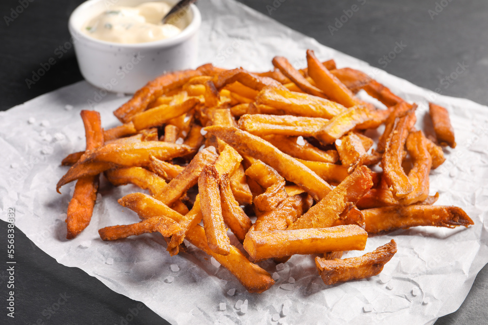 Delicious sweet potato fries and sauce on black table, closeup Delicious sweet potato fries and sauce on black table, closeup