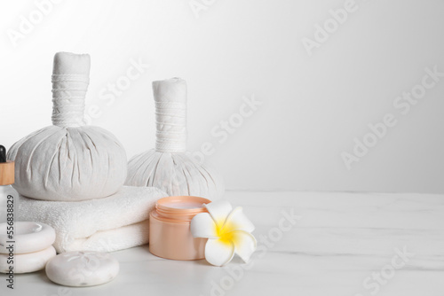 Spa composition with care products on white marble table. Space for text