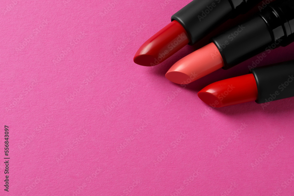 Beautiful lipsticks on pink background, above view. Space for text Beautiful lipsticks on pink background, above view. Space for text