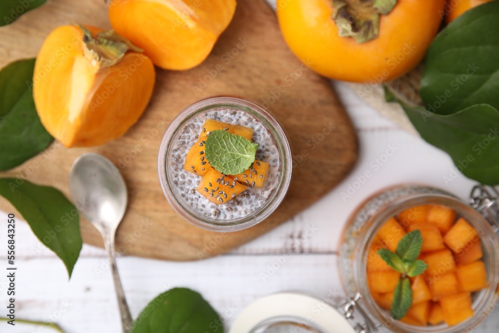 Delicious dessert with persimmon and chia seeds on table, flat lay Delicious dessert with persimmon and chia seeds on table, flat lay