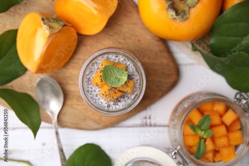 Delicious dessert with persimmon and chia seeds on table, flat lay