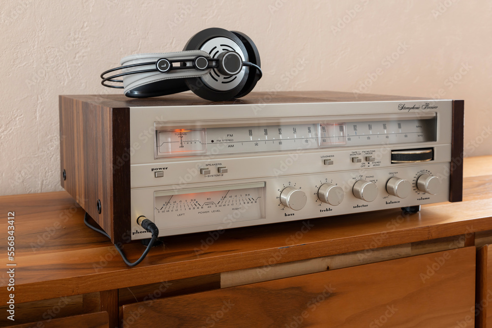 Obraz premium Home Stereo Receiver with Headphones Placed on Wooden Retro Shelf