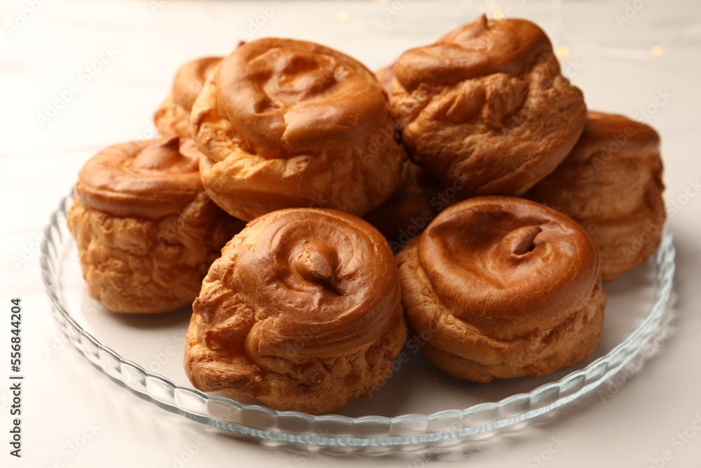 Delicious profiteroles on white table, closeup view