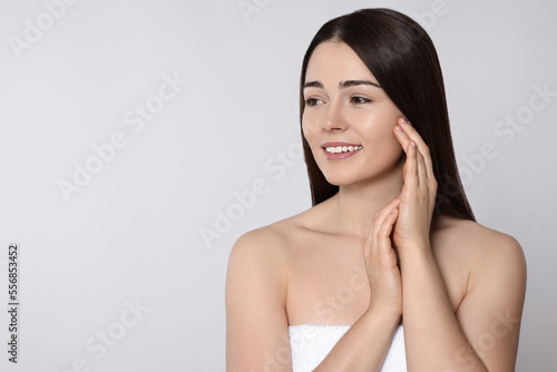 Portrait of attractive young woman on light grey background, space for text. Spa treatment