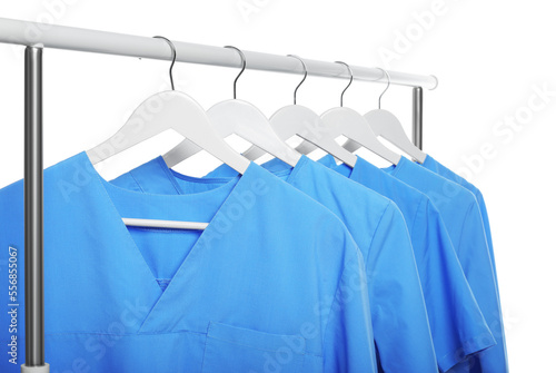 Light blue medical uniforms on rack against white background photo