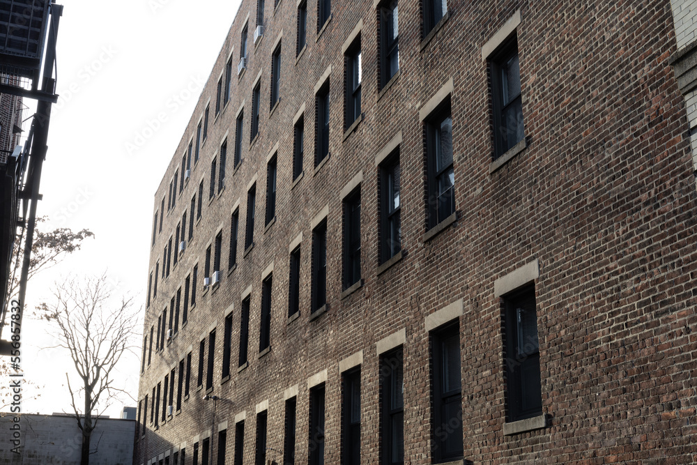 Perspective view of a featureless brick urban apartment building with rows of windows, horizontal aspect Perspective view of a featureless brick urban apartment building with rows of windows, horizontal aspect