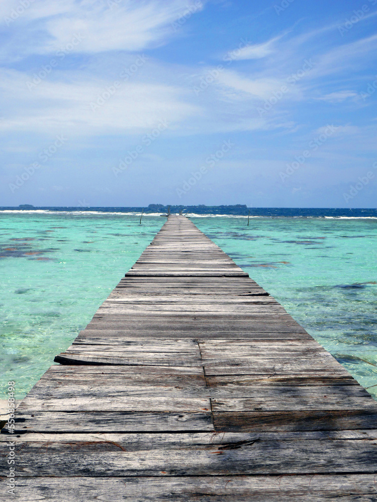 Wooden pier on beach with crystal clear turquoise waters