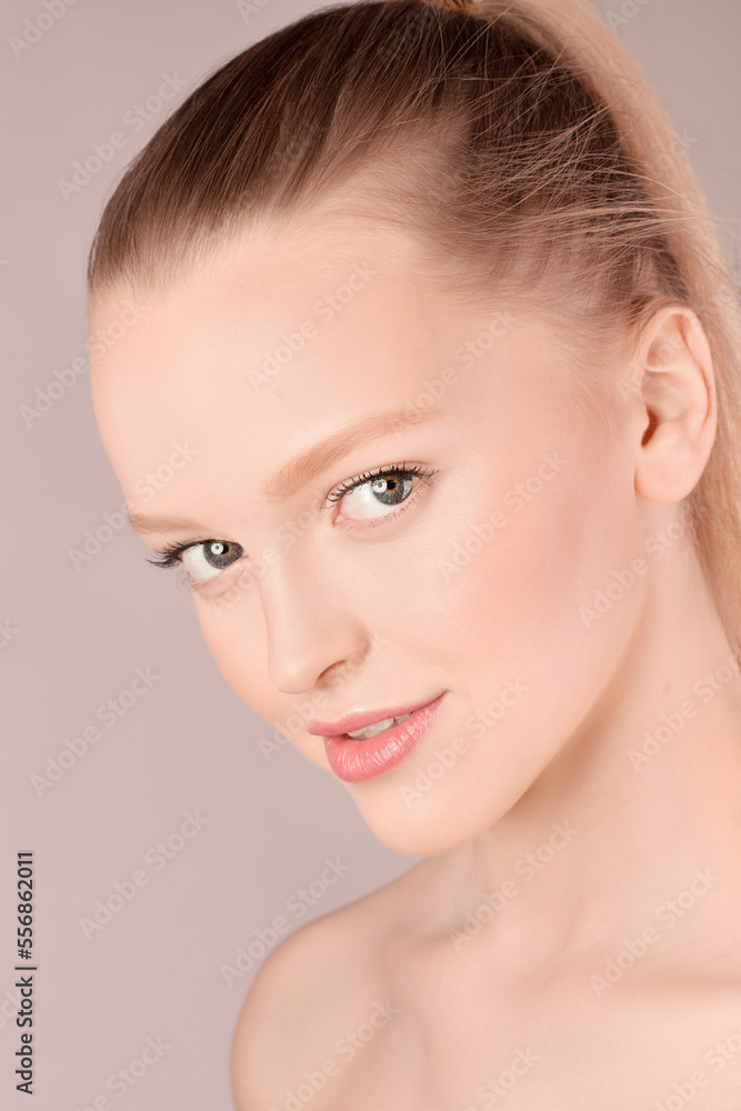 Portrait of blond-haired Caucasian pretty girl with soft makeup and bare shoulders looking at camera with coquettish smile Portrait of blond-haired Caucasian pretty girl with soft makeup and bare shoulders looking at camera with coquettish smile