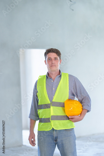 Supervisor male engineer wearing a protective vest and safety hard hat.in construction site for building site survey in civil engineering project.