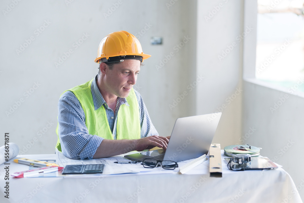 Architect concept, Architects working with blueprints in the office Business accessories (laptop, smartphone, pens, magnifier), accessories for drawing (plans, rulers) and learning on the table