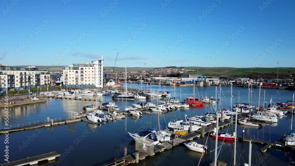 Drone shot flying backwards over marina with yachts and boats in sun Drone shot flying backwards over marina with yachts and boats in sun