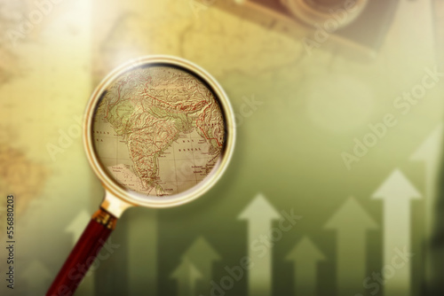 Magnifying glass on vintage retro India map economy upgrade. Vintage camera on antique Indian map. Indian GDP Up. Increasing Indian GDP.