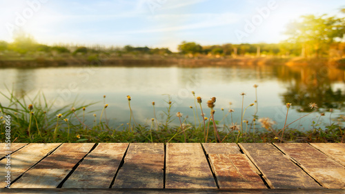 Beautiful wooden floor and lake or river background in nature with grass field.
