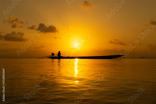 Silhouette of fishermen on the lake with sunset sky.