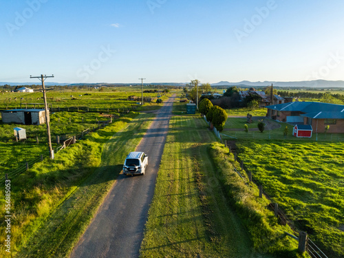 Four wheel drive car travelling through farmland on narrow country road trip adventure photo