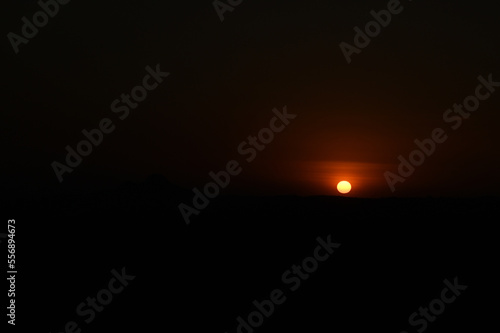 Silhouette image of a hill. Image of a Sunset behind the hill