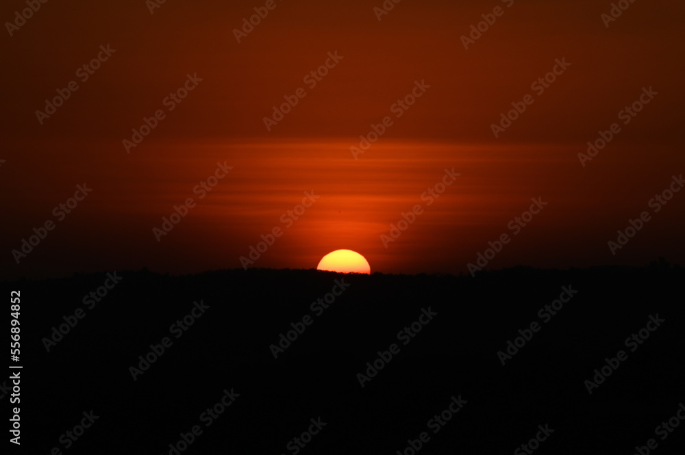Silhouette image of a hill. Image of a Sunset behind the hill