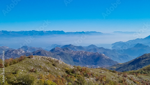 Panoramic view of dramatic karst mountain chains Dinaric Alps surrounding the Lake Skadar National Park seen from Goli Vrh, Montenegro, Balkan, Europe. Valley is covered by mystical fog, blue hills © Chris