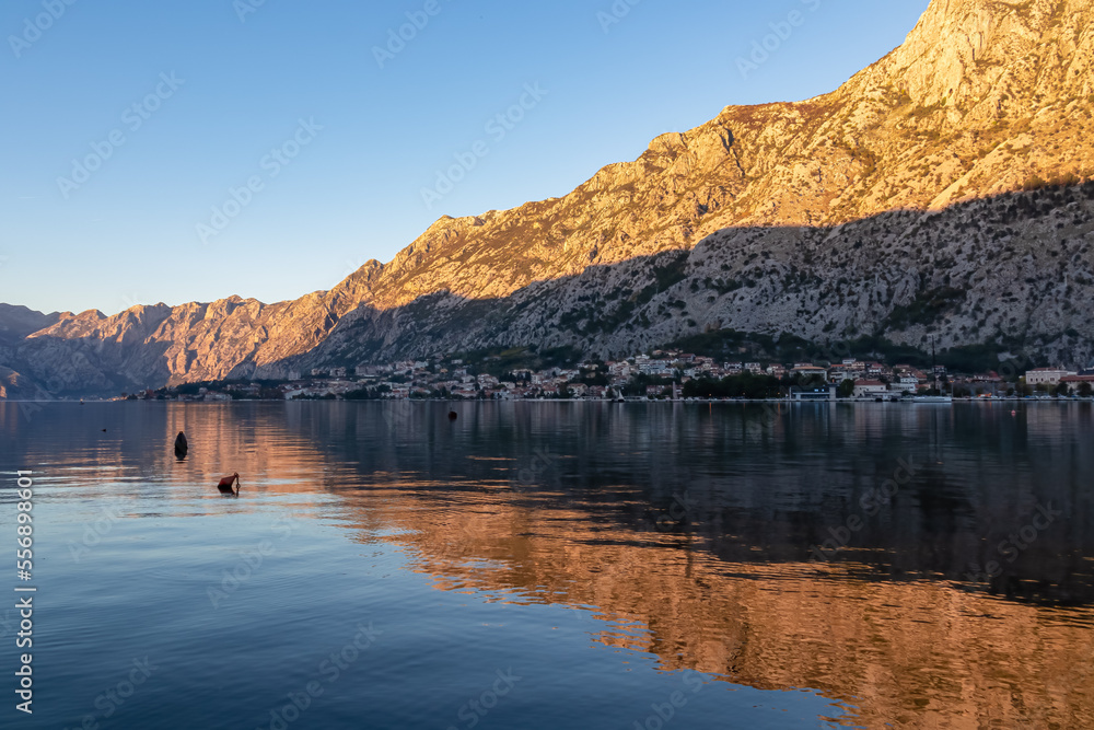 Scenic view of Kotor Bay (Boka) with dramatic mountain reflections at sunset seen from coastal town Muo, Adriatic Mediterranean Sea, Montenegro, Balkan, Europe. Perast, Lovcen Mountain in background