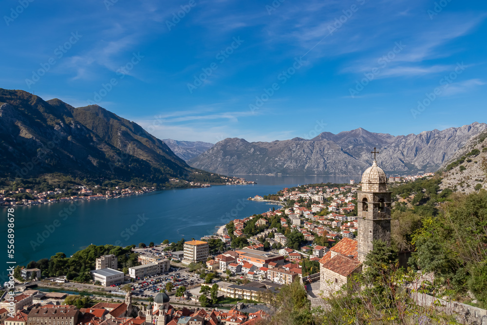 Panoramic view from Kotor city walls on Church of Our Lady of Remedy and Kotor bay in sunny summer, Adriatic Mediterranean Sea, Montenegro, Balkan Peninsula, Europe. Fjord winding along coastal towns