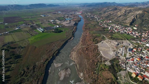 River of Shkumbin in Albania flowing through agricultural parcels and countryside photo