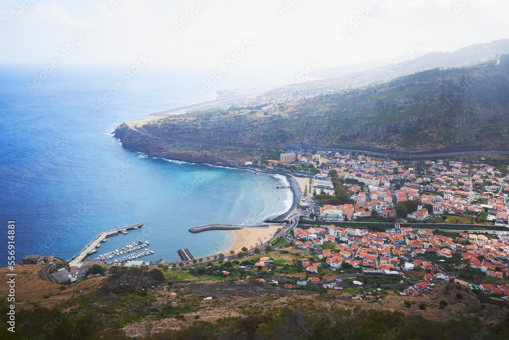 View of Machico city, Madeira, Portugal. Beach, sea and airport in the background.
