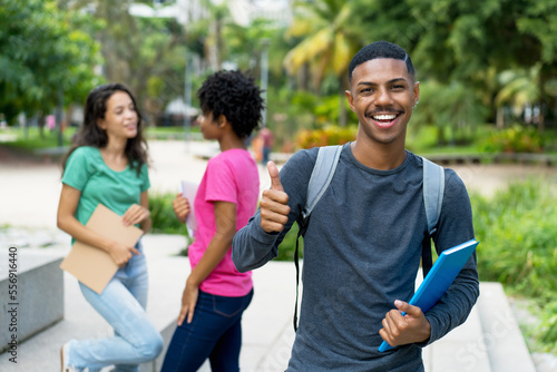 Successful african american male student with group of brazilian female young adults