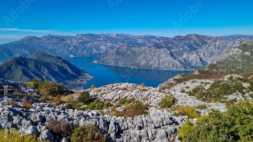 Panoramic view from Pestingrad (Derinski Vrh) of Kotor bay in sunny summer, Adriatic Mediterranean Sea, Montenegro, Balkan Peninsula, Europe. Fjord winding along coastal towns. Lovcen, Orjen mountains photo