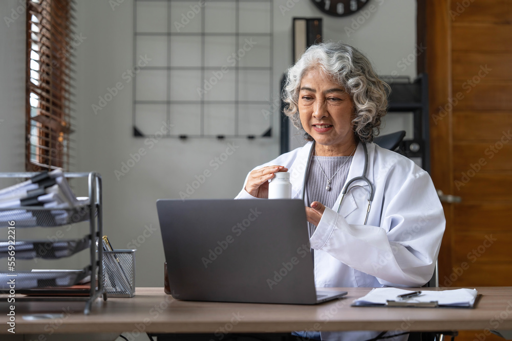 Asian senior doctor hospital medical medicine health care clinic office. using laptop computer. Asian senior doctor hospital medical medicine health care clinic office. using laptop computer.