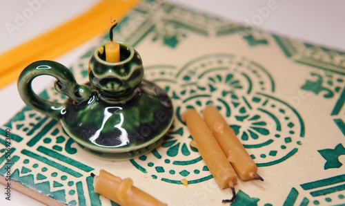 Church candle in green candlestick near icons ,orthodox faith