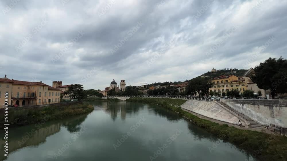Verona old town cityscape from Adige river on cloudy day, San Giorgio in Braida church in background. Italy Verona old town cityscape from Adige river on cloudy day, San Giorgio in Braida church in background. Italy