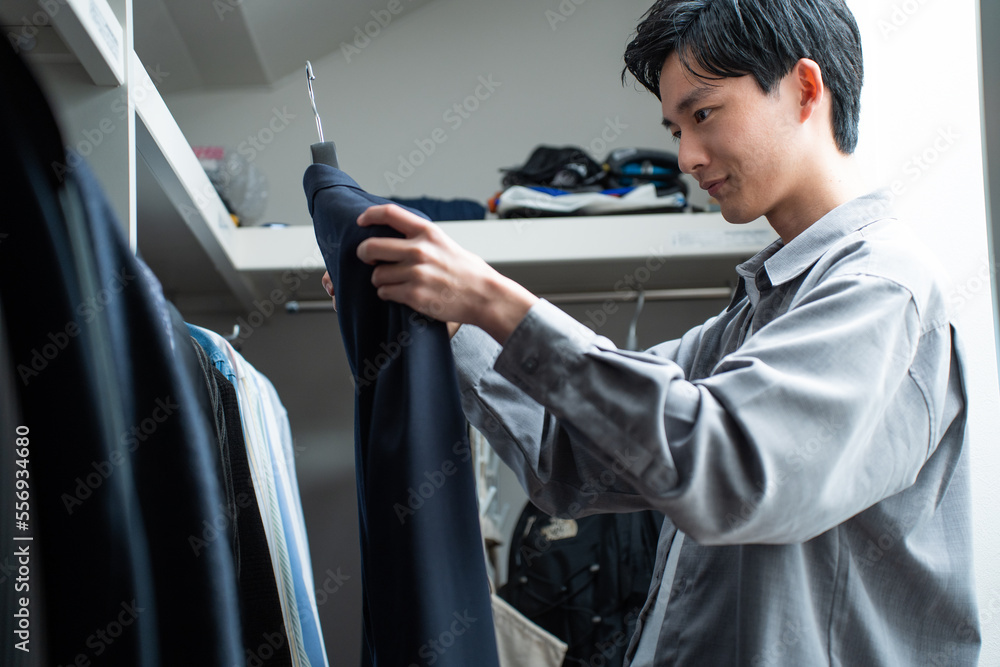 Obraz premium クローゼットで服を選ぶ日本人男性