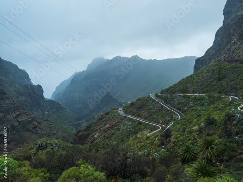 Dramatic lush green landscape with winding curvy mountain road towards Masca village situated in a picturesque valley, Tenerife, Canary Islands, Spain. rainy day, moody sky