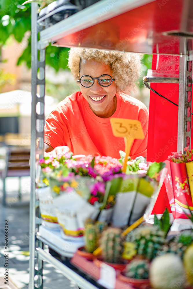 Obraz premium A woman buyer selects bouquets before buying at a flower shop on the street