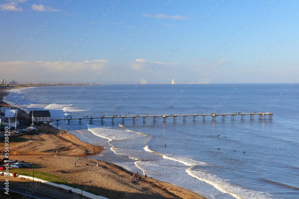 Panoramic Landscape image of Saltburn on a sunny afternoon with lots of people surfing. Saltburn, North Yorkshire, England, UK.