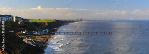 Panoramic Landscape image of Saltburn on a sunny afternoon with lots of people surfing. Saltburn, North Yorkshire, England, UK. photo