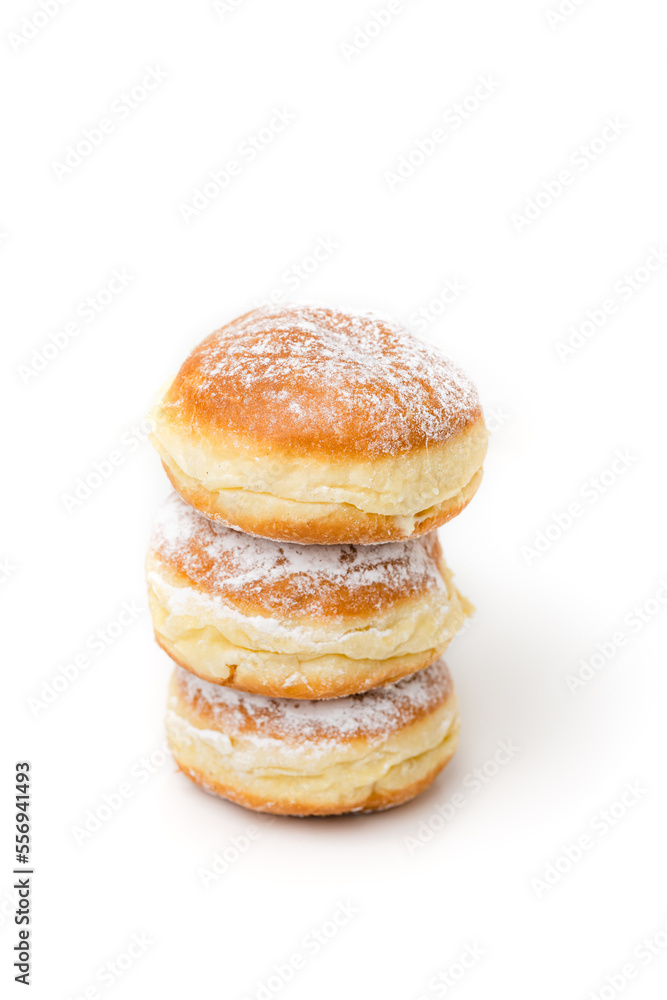 Stack of Krapfen, Kreppel or Berliner doughnuts dusted with powdered sugar on white background, traditional German fried Brioche dough pastry filled with vanilla custard or jam for New Year's party Stack of Krapfen, Kreppel or Berliner doughnuts dusted with powdered sugar on white background, traditional German fried Brioche dough pastry filled with vanilla custard or jam for New Year's party